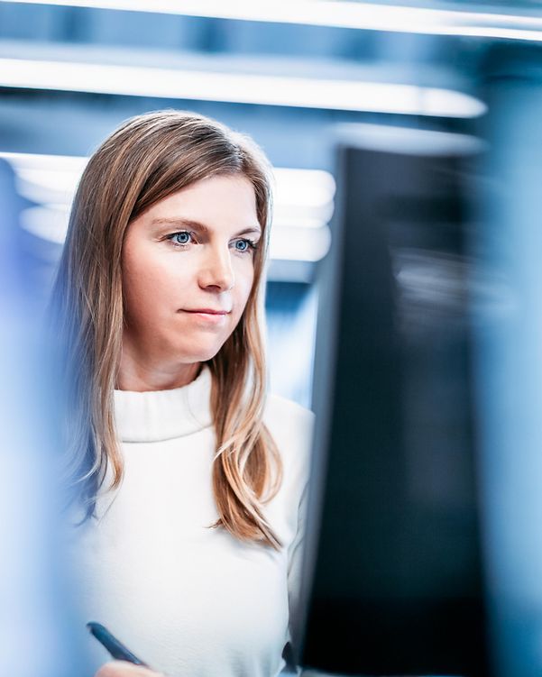 Frau, die auf Computermonitor im modernen Büro schaut