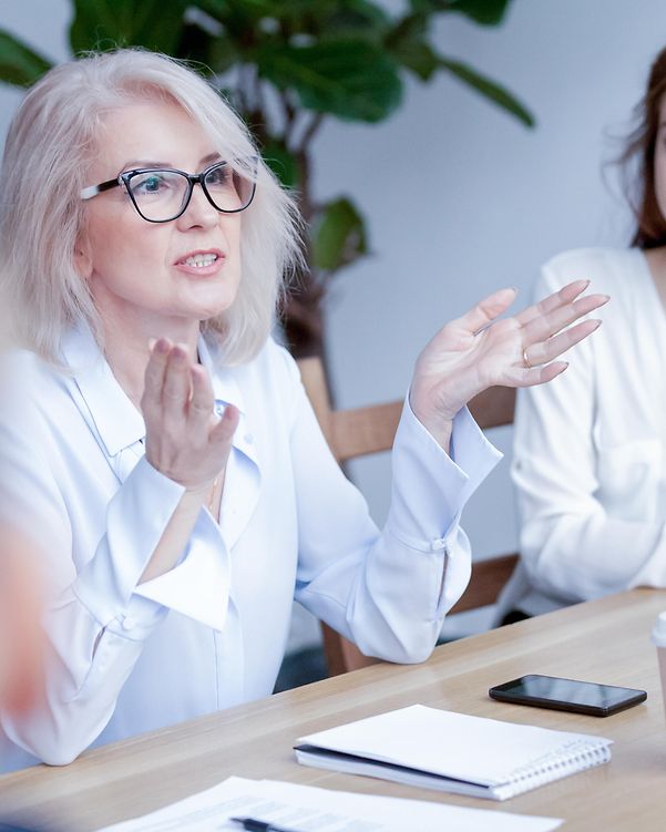 Mitarbeiterin im Büro sprechen über die vielseitige Kompatibilität des Gigaset N670 DECT 