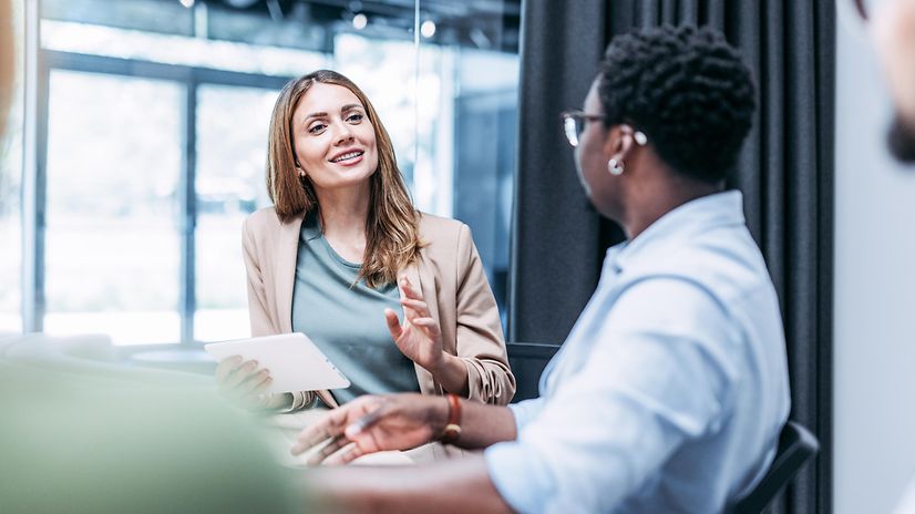 Eine junge Geschäftsfrau berät einen Kunden zu Copilot Studio