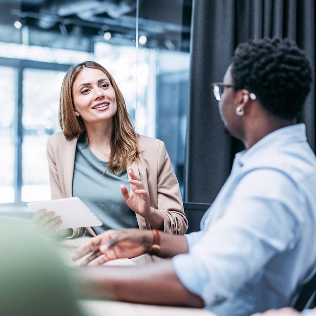 Eine junge Geschäftsfrau berät einen Kunden zu Copilot Studio