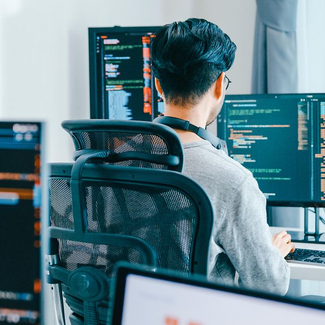 Mitarbeiter sitzt am PC und surft mit ultraschnellem Glasfaser der Telekom im Internet