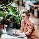 Junge Designerin eines kleinen Unternehmens, arbeitet am Laptop im Cafe und informiert sich über Cloud Infrastructure