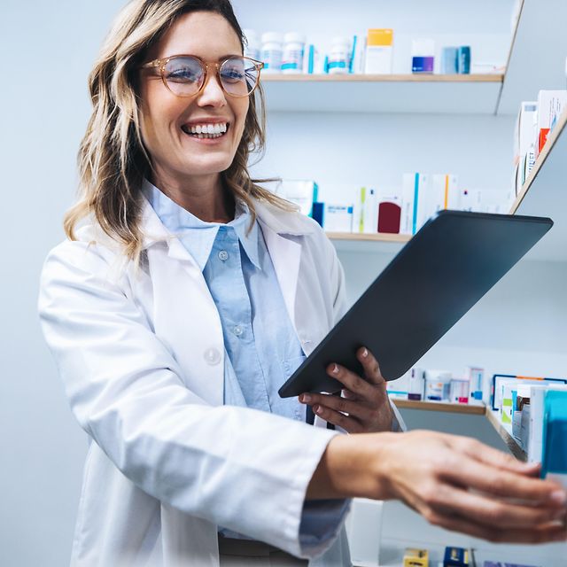 Telematik für Apotheken Eine Apothekerin arbeitet an Ihrem Tablet und sucht relevante Medikamente aus