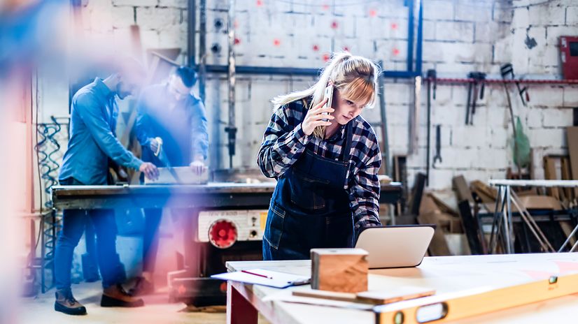 Frau in einer Werkstatt telefoniert mit einem ruggedized Gerät von Samsung