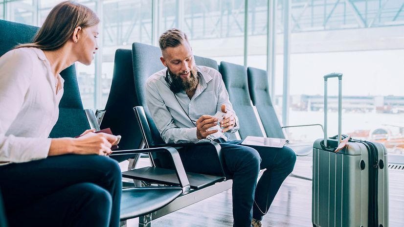 Geschäftsleute in einer Wartehalle tauschen Visitenkarten aus, um zum Thema Business Voice VPN in Kontakt zu bleiben