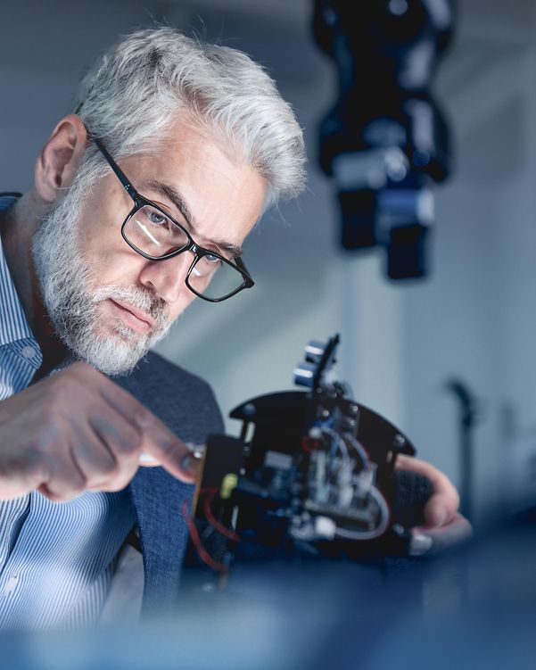 Geschäftsmann repariert Maschine. Bild soll symbolisierern, dass durch Agentforce Geschäftsprozesse optimiert werden können.