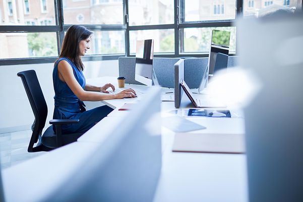 Frau im Ingenieurbüro sitzt am Computer