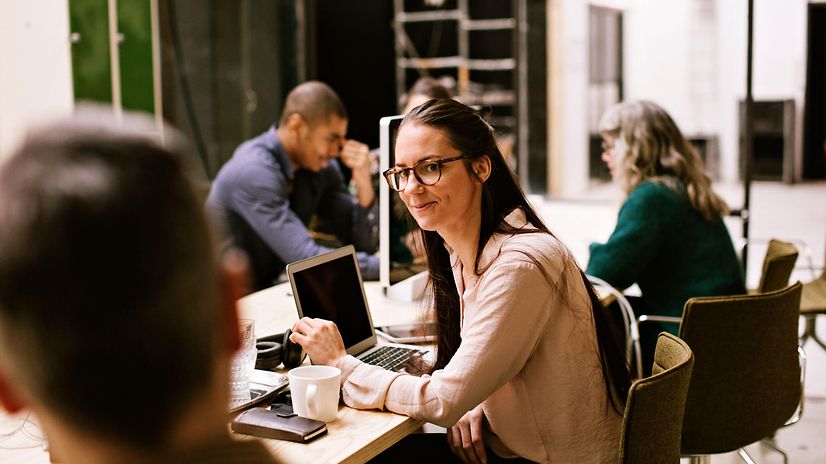 Mitarbeiter sitzen in einem Meetingtisch und freuen sich über CompanyFlex Services.