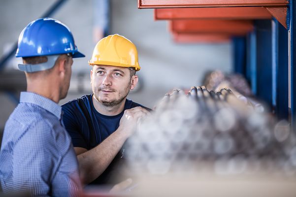Ein Mann mit einem Bauhelm schaut in die Kamera.