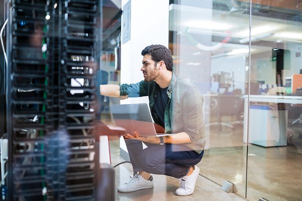 Ein Mann nimmt Einstellungen an einem Server in einem Büro vor.