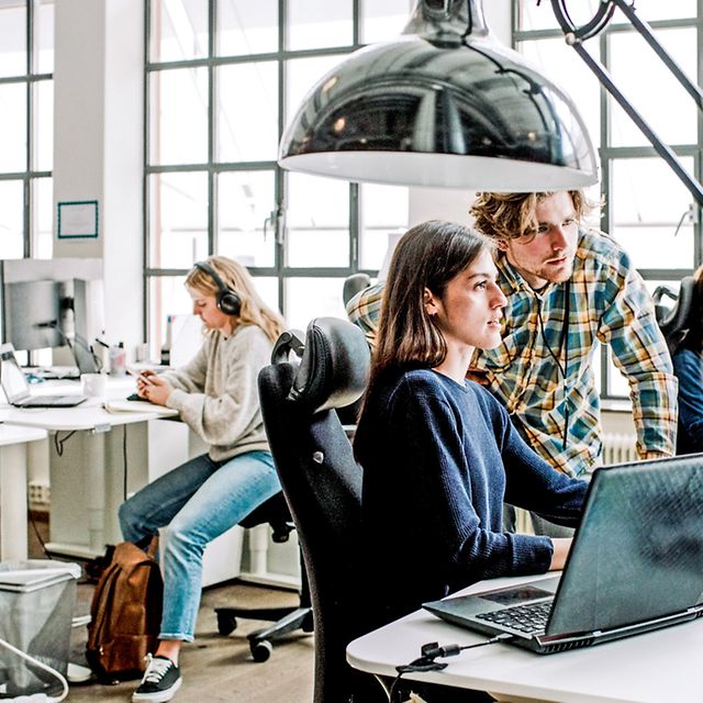 Zwei personen schauen gemeinsam auf einem Bildschirm den Flyer zu Microsoft Dynamics 365 an