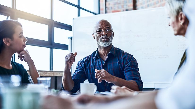 Ein kurzer Schnappschuss einer Gruppe von Geschäftskollegen im Büro, die bei einer Besprechung Pläne für die Zukunft besprechen.