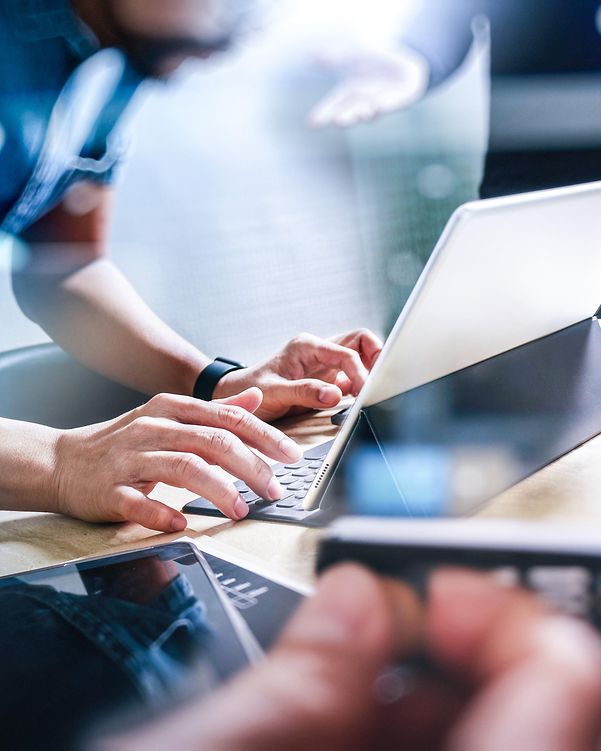 Ein Mann tippt auf seinem Laptop und nutzt die Domain Name System Security Extensions der Telekom.