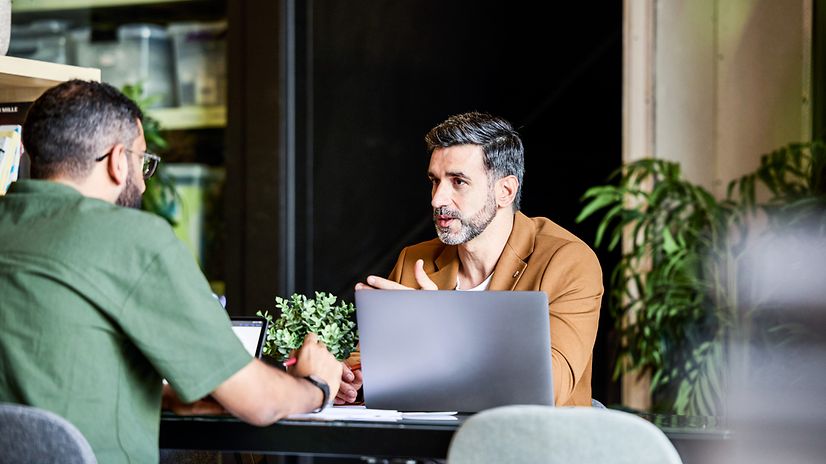 Zwei Kollegen im Gespräch am Laptop Einblick in die Unternehmenskultur von T Business