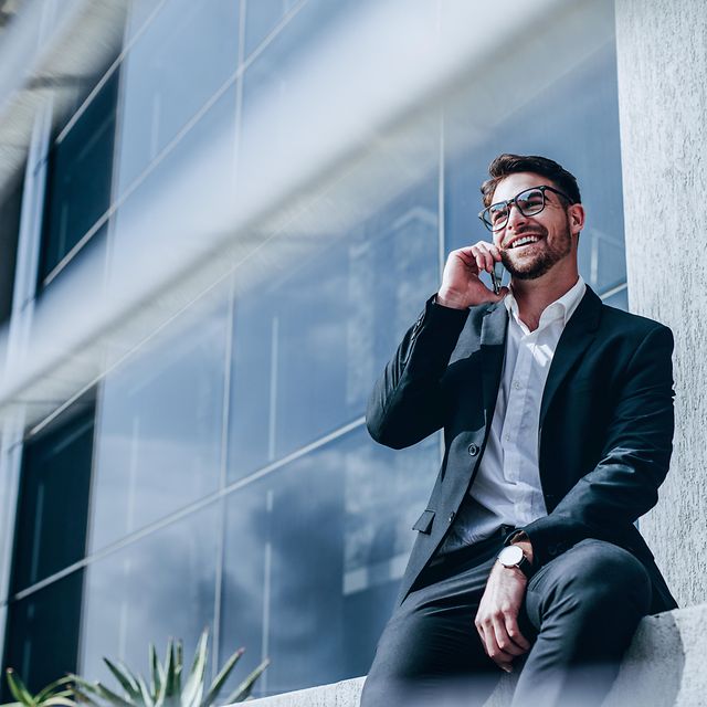 Geschäftsmann telefoniert mobil vor einem Bürogebäude – symbolisiert mobile Erreichbarkeit mit Festnetznummer
