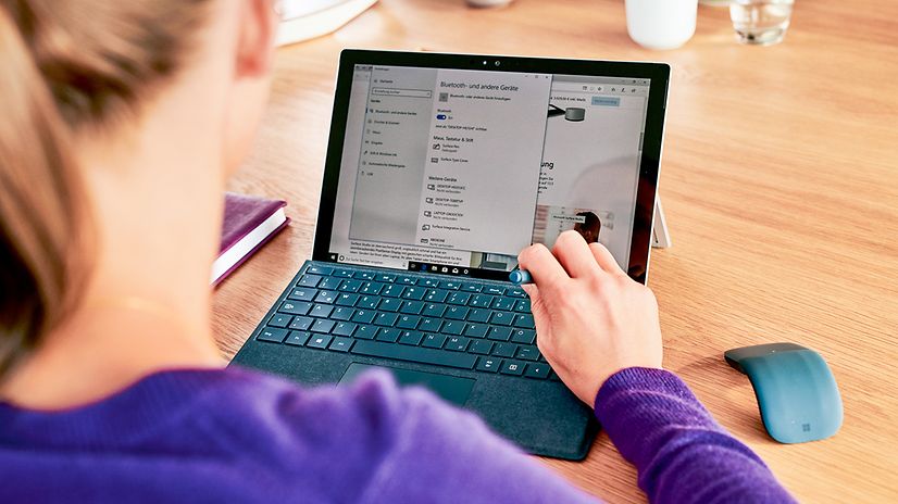 Bild zeigt eine Frau die vor Ihrem PC sitzt und auf den Bildschirm schaut