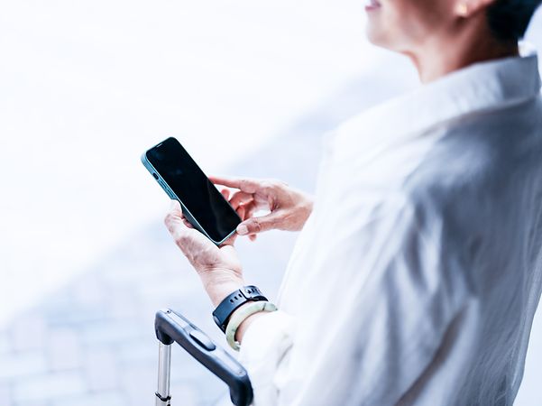 Geschäftsreisende nutzt Ihr Smartphone für eine sichere Datenübertragung