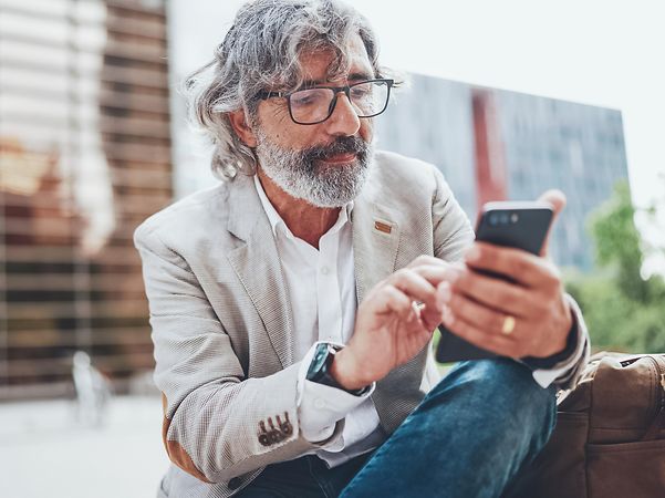 Ein Mann schaut auf sein Handy.