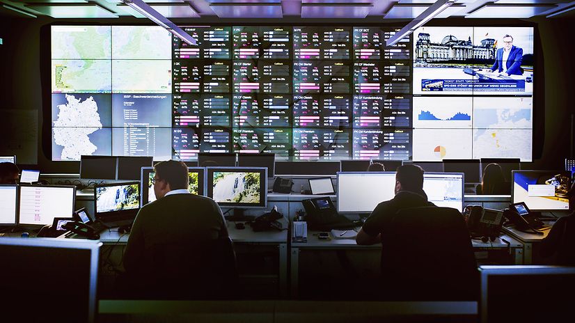 Blick in ein technisches Terminal. Arbeiter an Bildschirmen