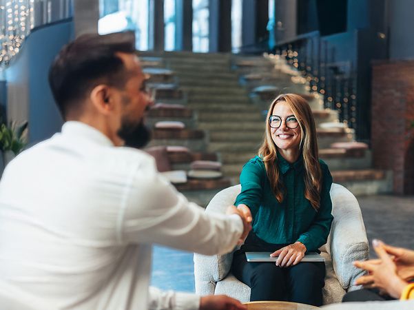 Frau und Mann geben sich zu Beginn eines Beratungsgespräches zu Swyx X die Hand.
