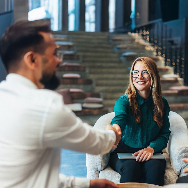 Frau und Mann geben sich zu Beginn eines Beratungsgespräches zu Swyx X die Hand.