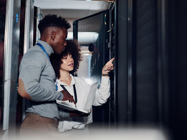 Zwei Personen inspizieren einen Serverschrank der Telekom