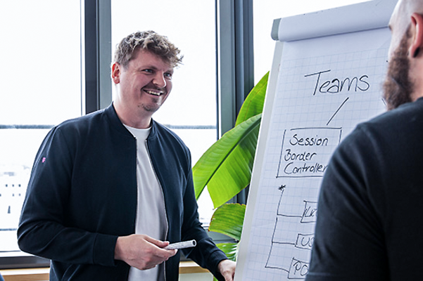 Persönliche Umstiegsberatung mit einem Berater vor einem Flip Chart zu Microsoft Teams Telefonie
