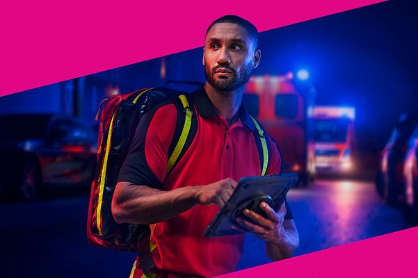 Sanitäter mit Tablet im Einsatz mit magentafarbenen Hintergrund.
