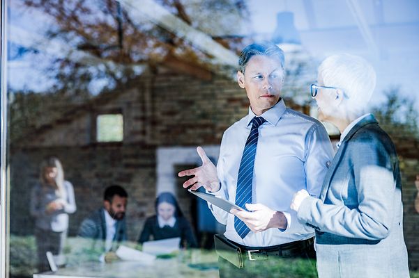Ein Mann und eine Frau sprechen über Telekom-Digitalisierungslösungen für den öffentlichen Sektor der Zukunft.