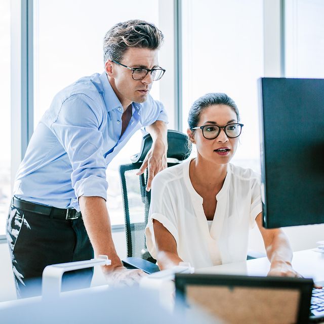 Zwei Personen schauen auf einen Computerbildschirm