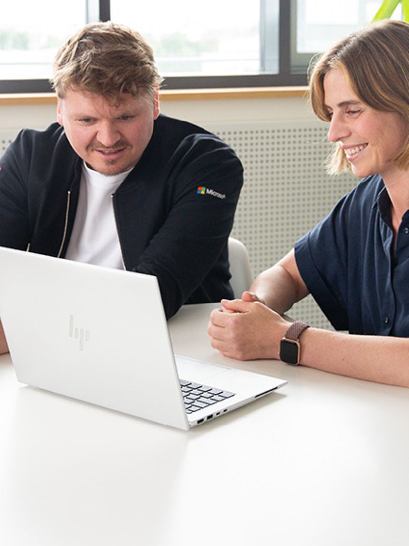 Zwei personen schauen gemeinsam auf einen Laptop-Bildschirm