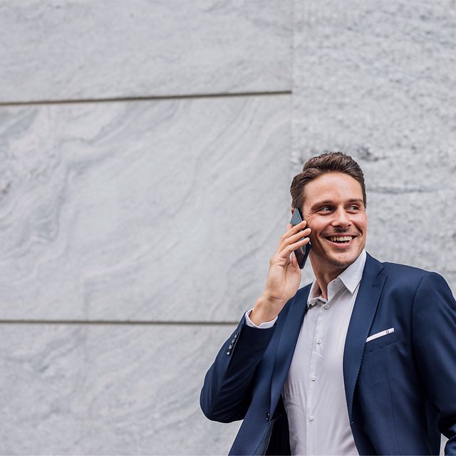 Mann mit Handy in der Hand telefoniert.